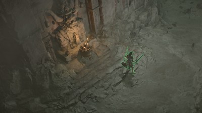 Player with green aura in front of glowing statue in wall.