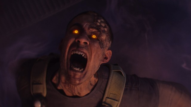 A yellow-eyed zombie looking up and screaming.