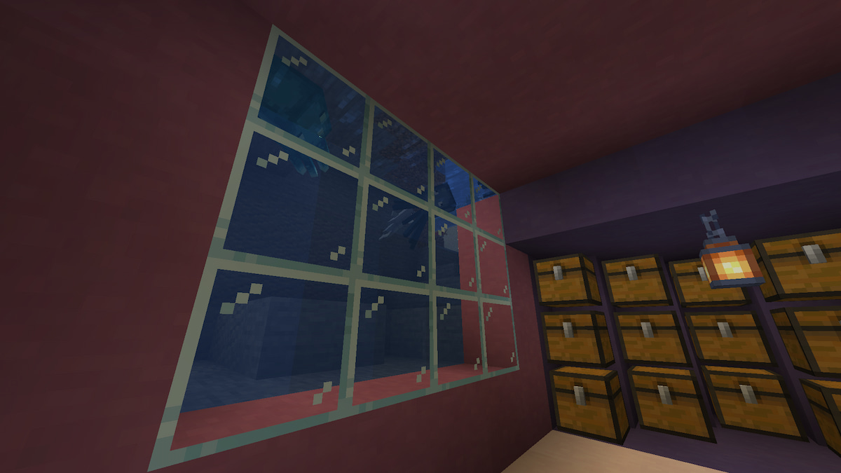 A view of an underground Minecraft base with a wall of chests and a window next to a river.