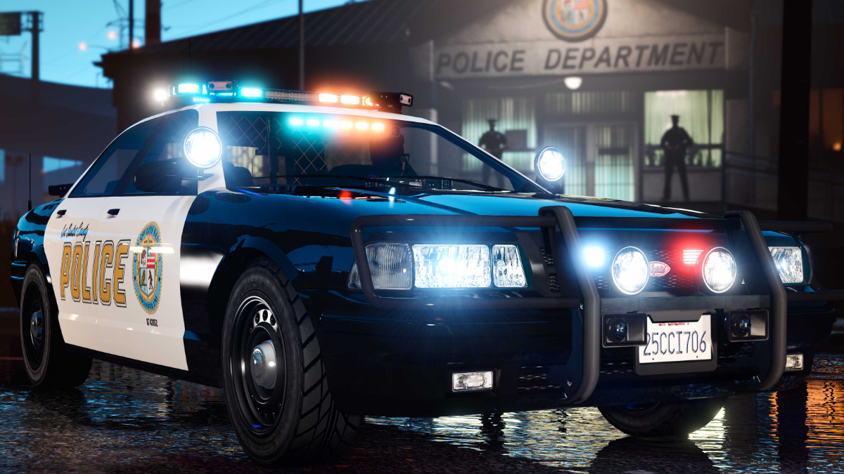 Black and white police car with headlights on and red and blue rack lights.