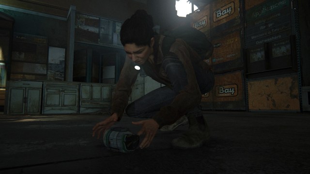 Dina crouching and placing a trap mine on the floor of a warehouse.