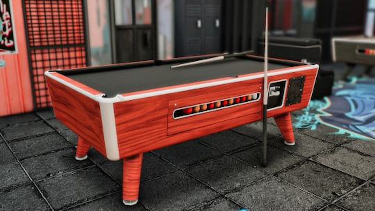 Pool table with balls and pool sticks leaning against the side
