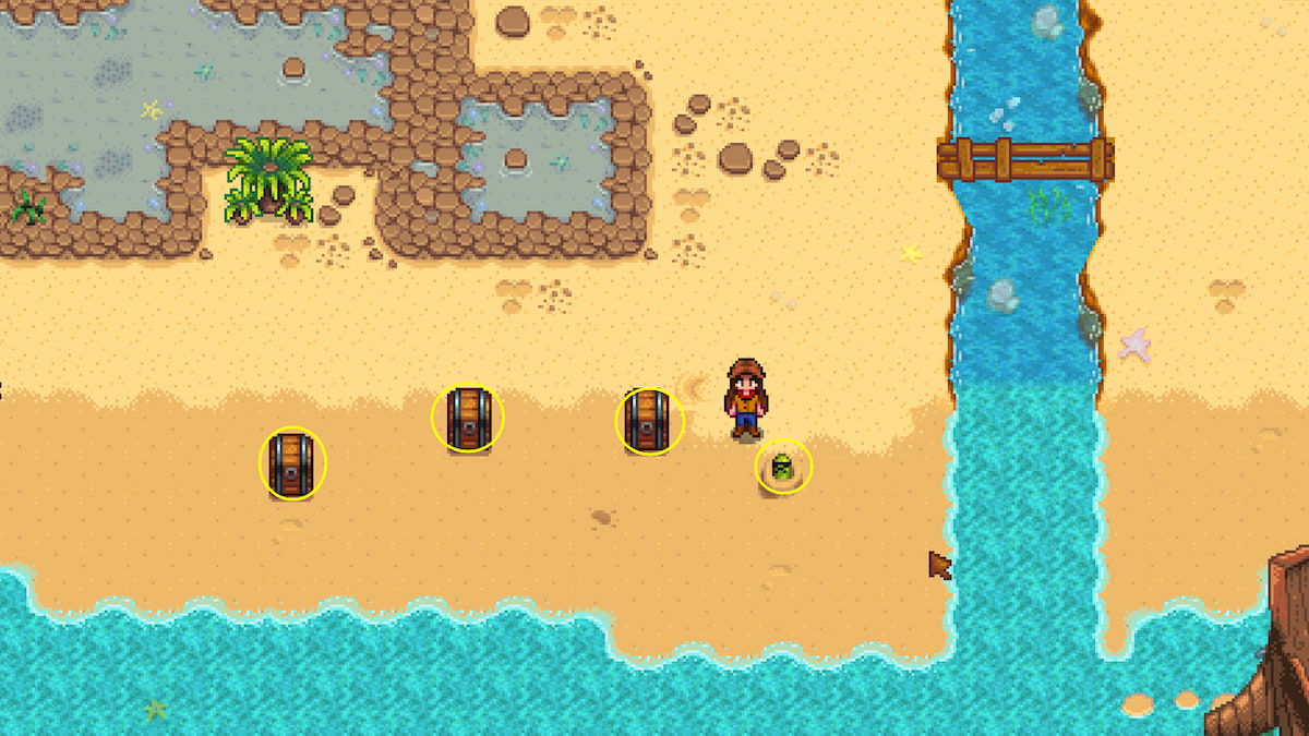 Three chests placed down on the beach and a green worm creature poking its head up beside it
