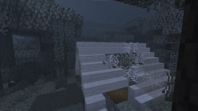 A Woodland Mansion appearing ominously in the fog in front of an abandoned camp in Minecraft