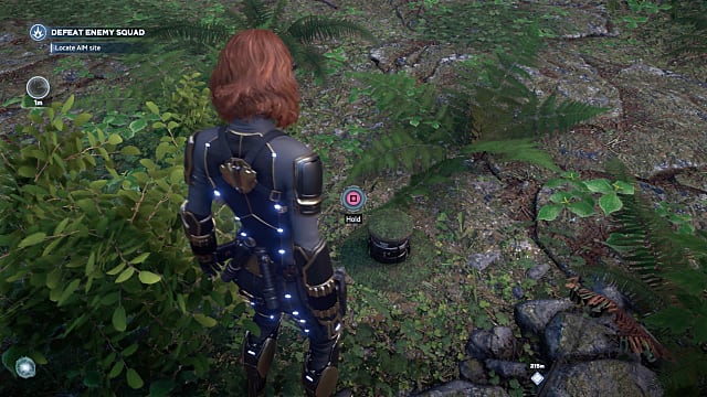 Black Widow standing over a mossy button on the ground, which opens the SHIELD Vault. 