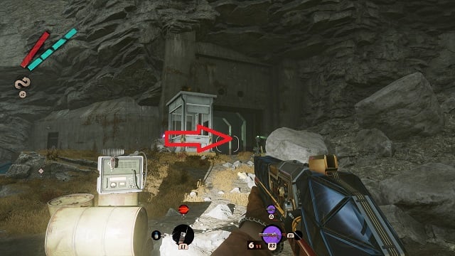 The player character looking at the entrance to Fia's bunker inside a cliff, with an arrow pointing to the code room.