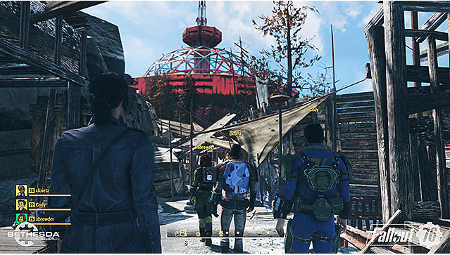 A group of four vault dwellers walk into a settlement with broken shacks and a red tower