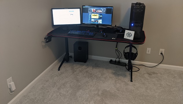 A full shot of the desk with monitors, computer tower, cup holder, headset hook, and mousepad.