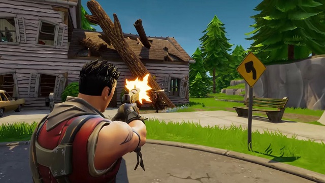 A male Fortnite player with spiked hair shoots a handgun at a running player near a broken down house