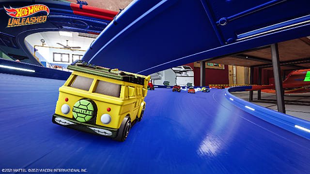 A yellow van with a Teenage Mutant Ninja Turtles vanity plate racing on a blue track.