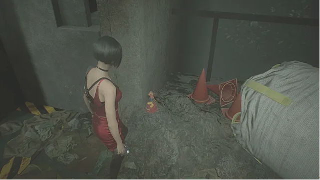 Ada Wong looking at a statue on the ground. 