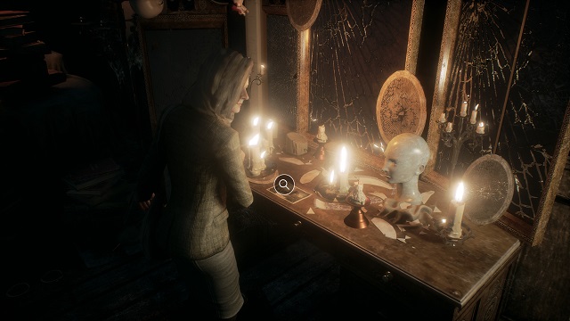 Reed Looks at a desk with a mannequin head on it in the attic in Remothered