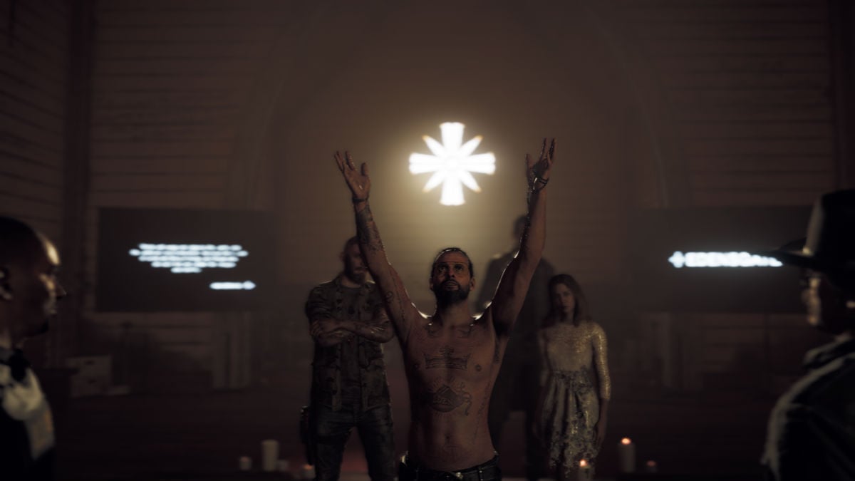 A shirtless cult leader stands with his arms raised to the heavens as followers look on in Far Cry 5