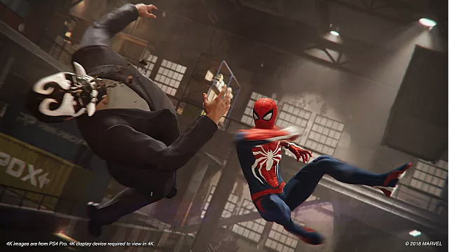 Spiderman jumps to punch a bad guy in the face in a warehouse