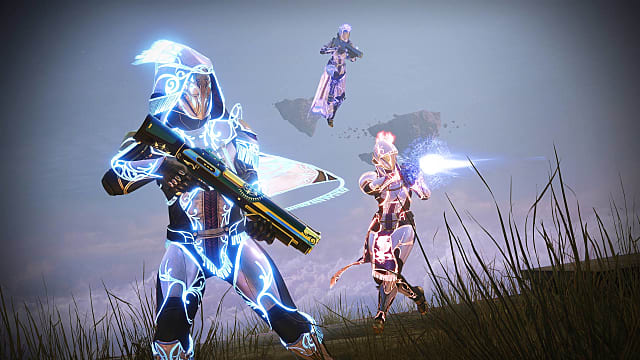 A Warlock floats behind a glowing blue Hunter and a Titan shooting.